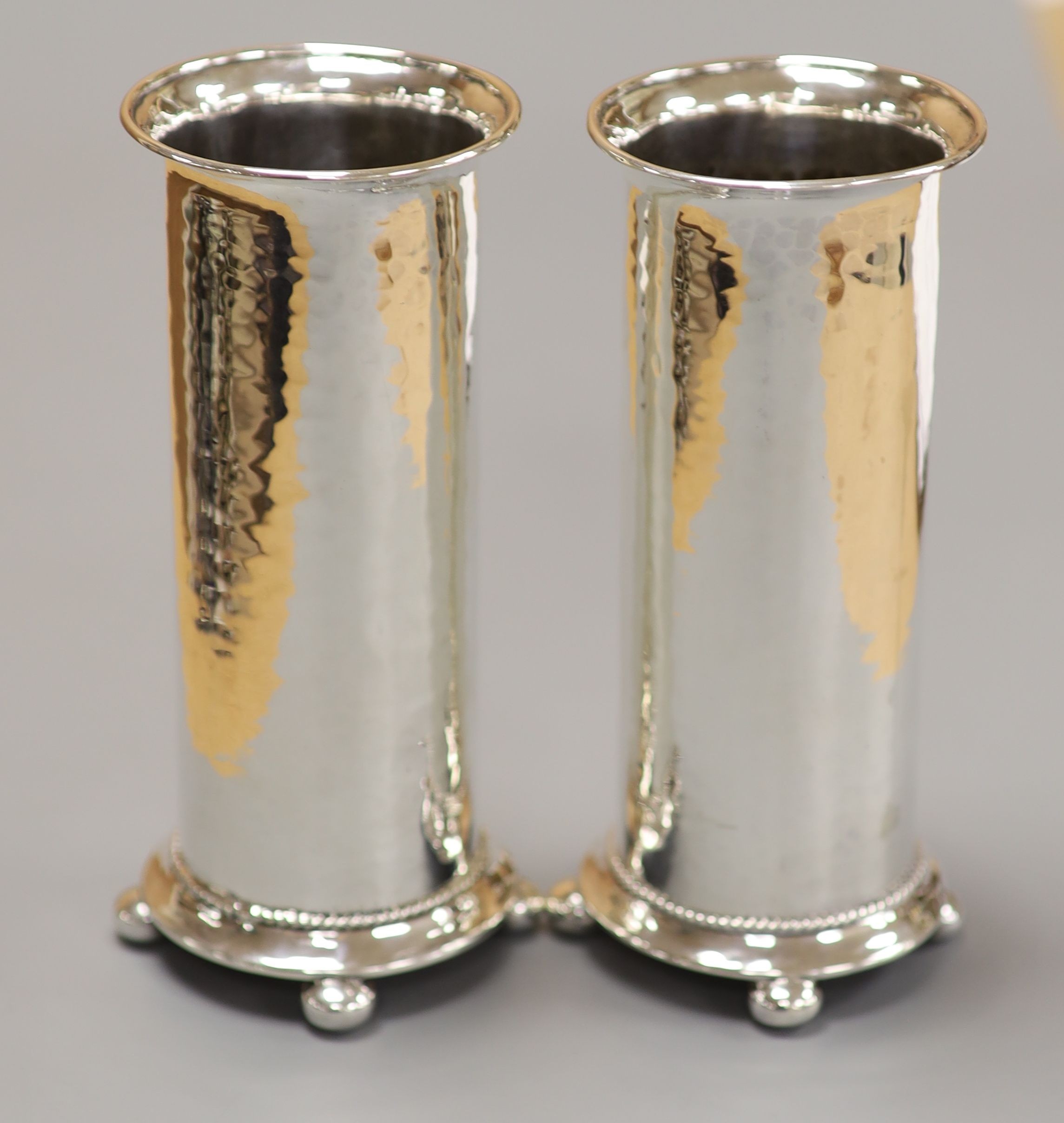 A pair of George V Arts & Crafts silver cylindrical posy vases by Albert Edward Jones, Birmingham, 1917, 14.7cm, 8oz.